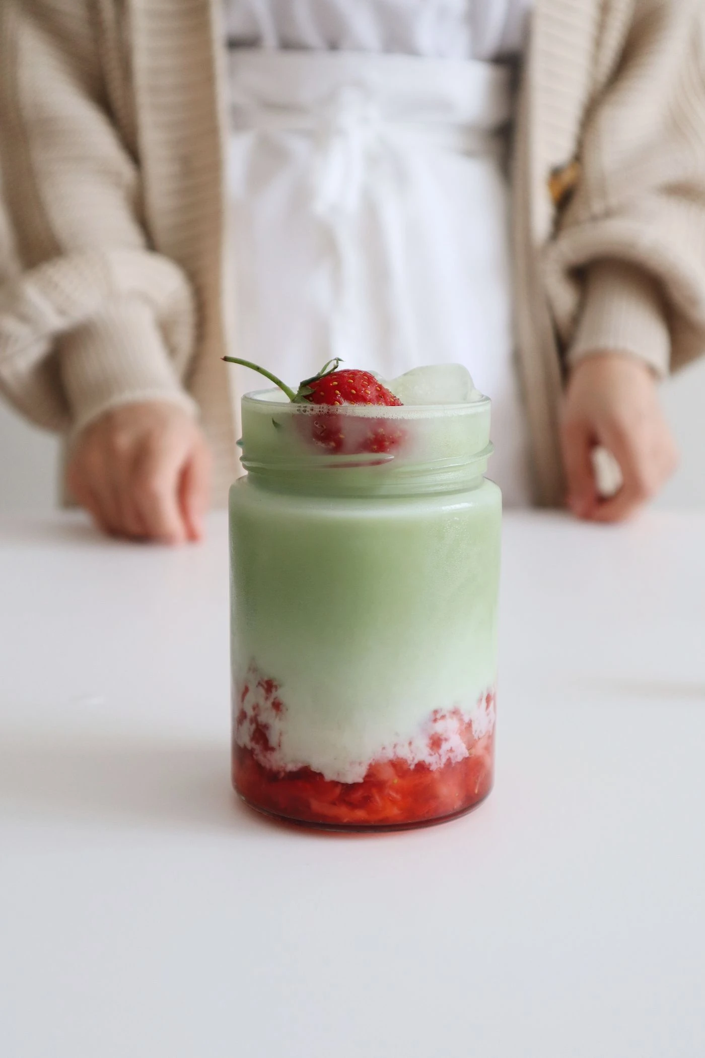 Matcha and strawberry milk in a complete glass jar
